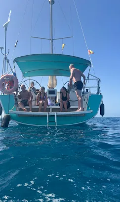 Guests relaxing on the stern of a sailing yacht with the swim ladder down