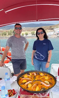 Zwei Gäste bei einer privaten Yachtcharter mit großer Meeresfrüchte-Paella an Bord